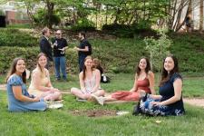 A group of of students seated in a grassy area
