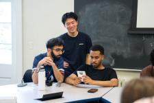Students play a video game on a handheld device