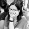 woman with dark hair and glasses smiling