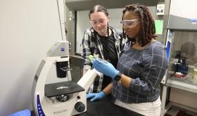 UVA grad student observing a Hampton University student working in a chemical engineering lab