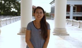 Chemical engineering graduate student seated at the Rotunda, with white columns in the background
