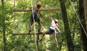 two students go through a rope course together