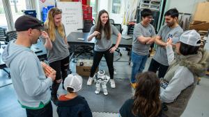 Students show a robot to attendees