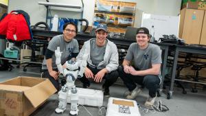 Students pose with a robot