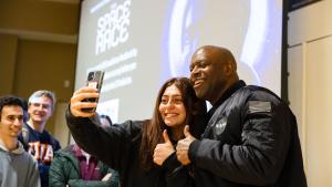 Leland Melvin poses for a photo with a student